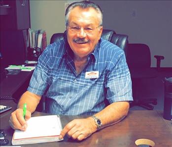 male employee with grey hair and glasses sitting at a desk