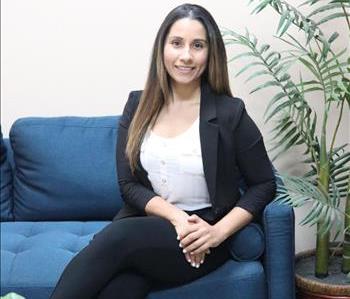 female employee with brown hair sitting on a couch for profession headshot